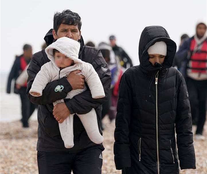 A group of people thought to be migrants, including young children, walk up the beach in Dungeness. Picture: Gareth Fuller