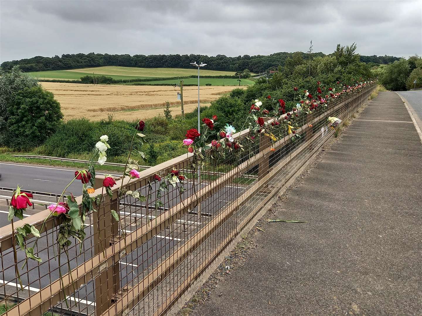 Individual flowers have been attached to the railings on both sides of the bridge