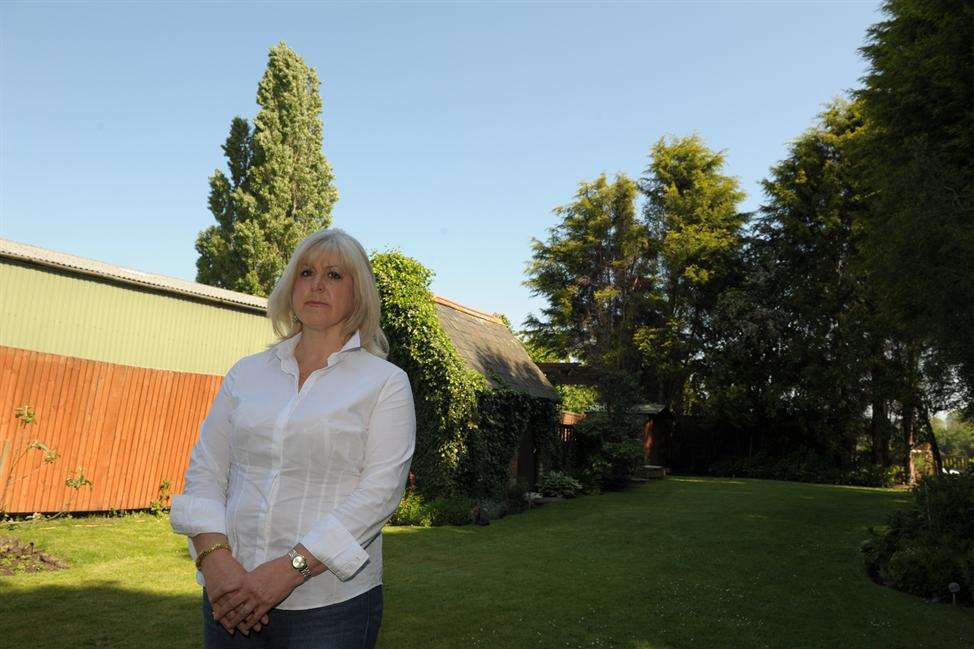 Helen Walker in her garden, standing in front of where the trees were cut down