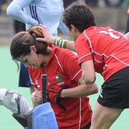 Jen Wilson receives treatment after being struck on the head at a penalty corner.