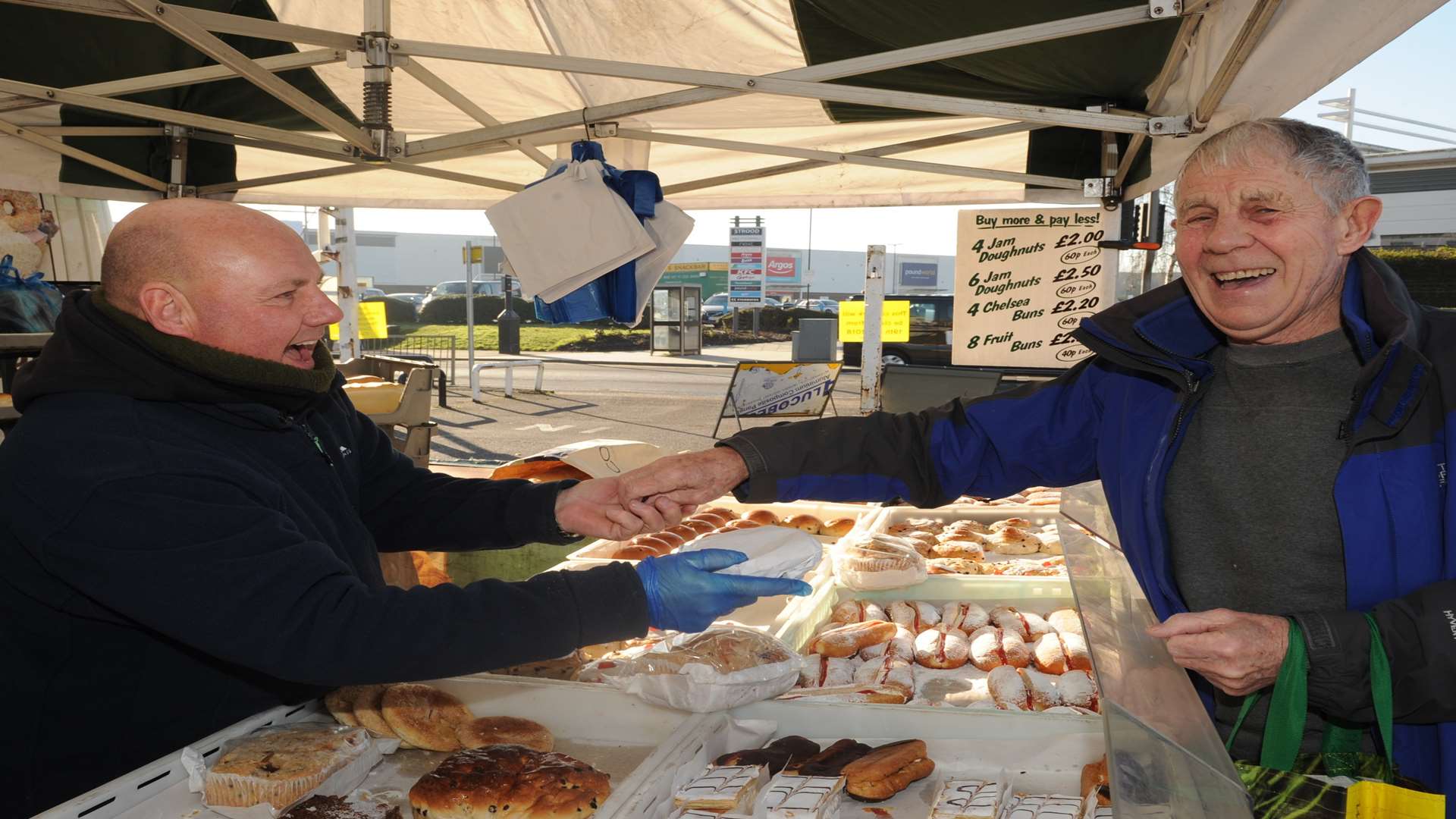 Alan Tridgell serving a bun to Ray Smeed at Strood market.