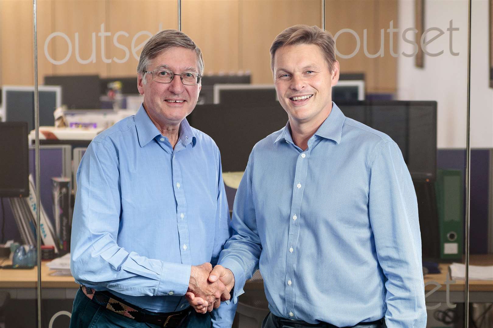 Outset Group chief executive Jonathan Gauton, right, shakes hands on the takeover with Nicholas Moore