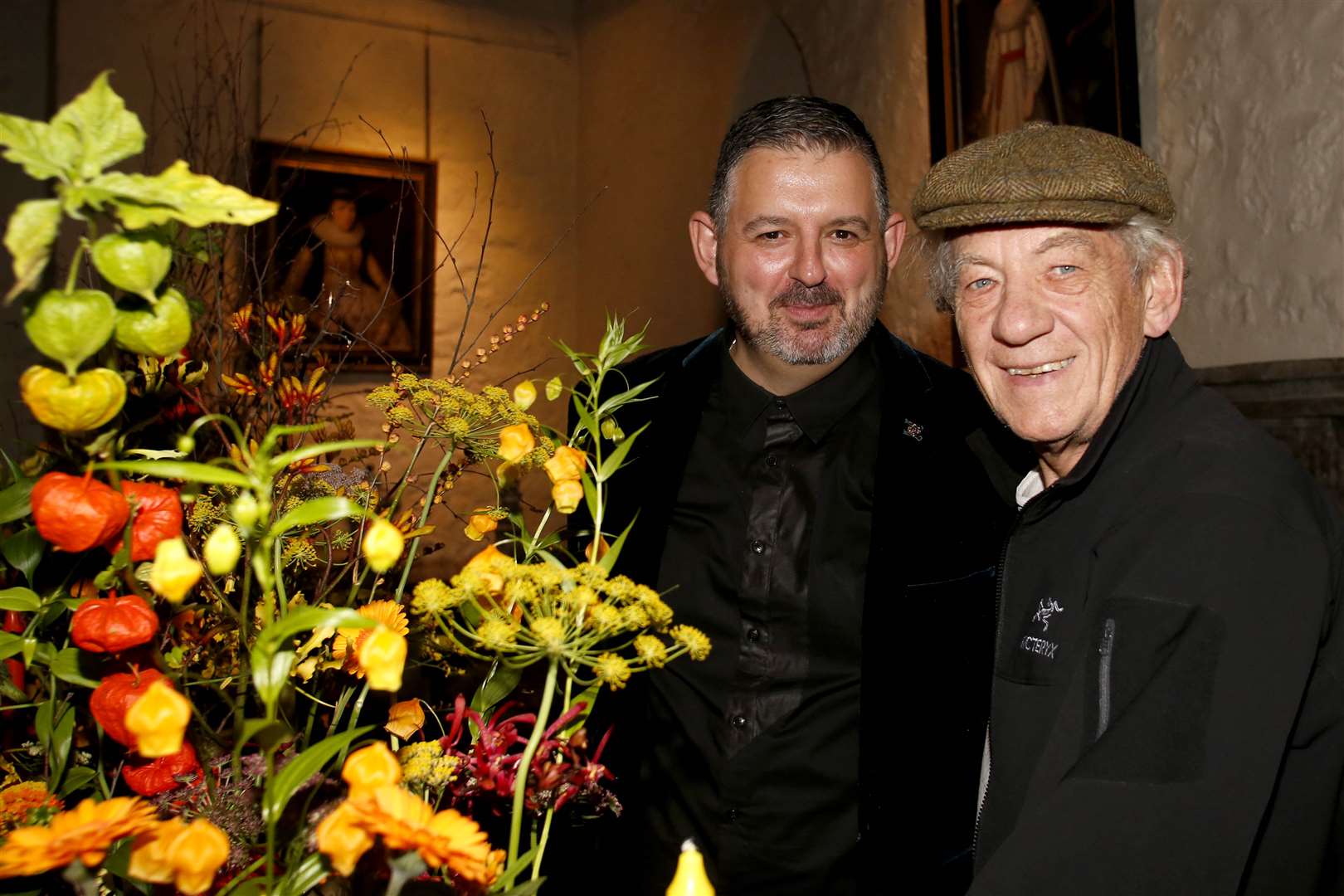 Festival designer Mig Kimpton shows Sir Ian McKellen the floral design in the Queen’s Gallery. Picture: Gary Hawkins Photography.