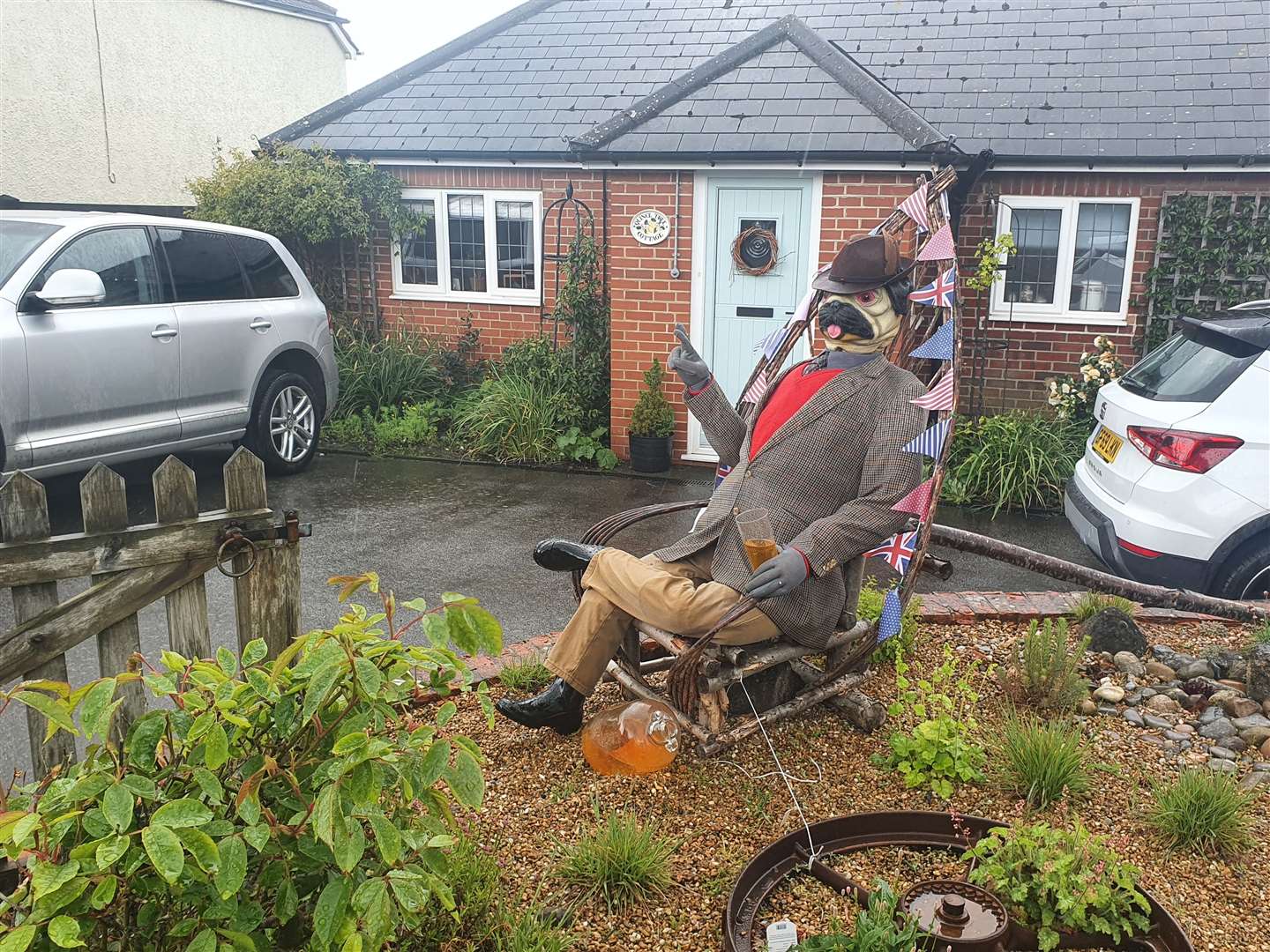 A patriotic gentleman reclines with a drink in a front garden