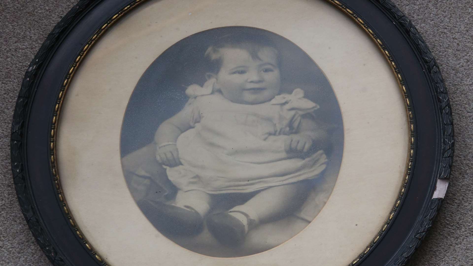 A portrait of a toddler in an oval wooden frame was one of two framed portraits found under floorboards of a house in Minster
