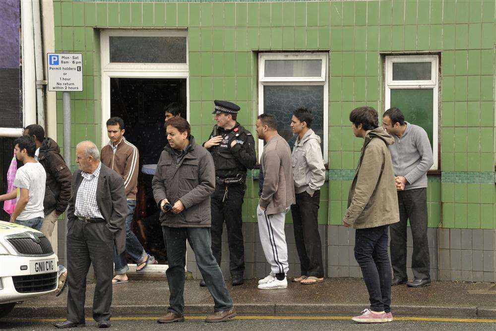 The faithful leaving the mosque after Friday prayers, watched over by PC Dave Saunders