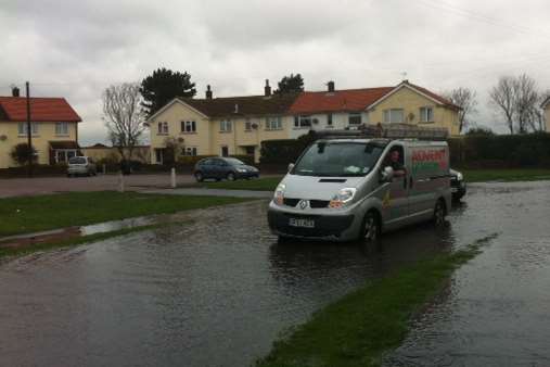 Vehicles negotiate the flood water in Deal