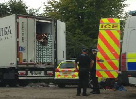 Police by the truck which contained 26 illegal immigrants.