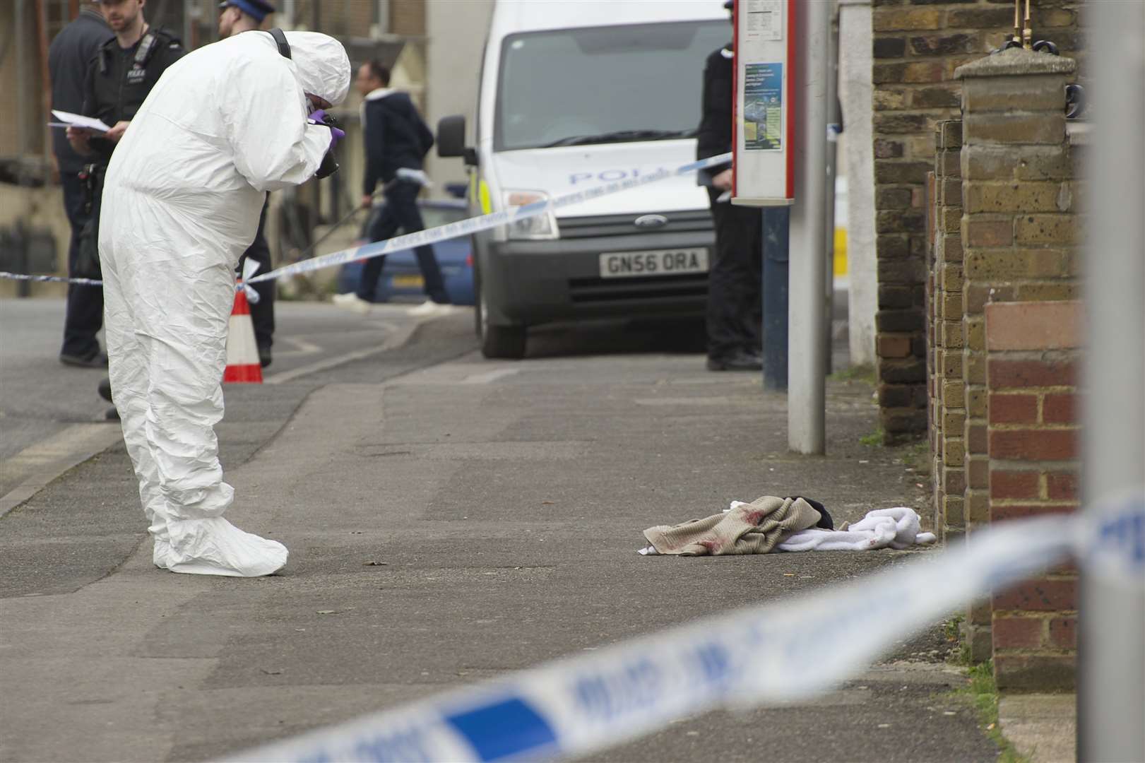 A Police forensics officer gathers evidence at the crime scene in Milton Road, Gravesend.