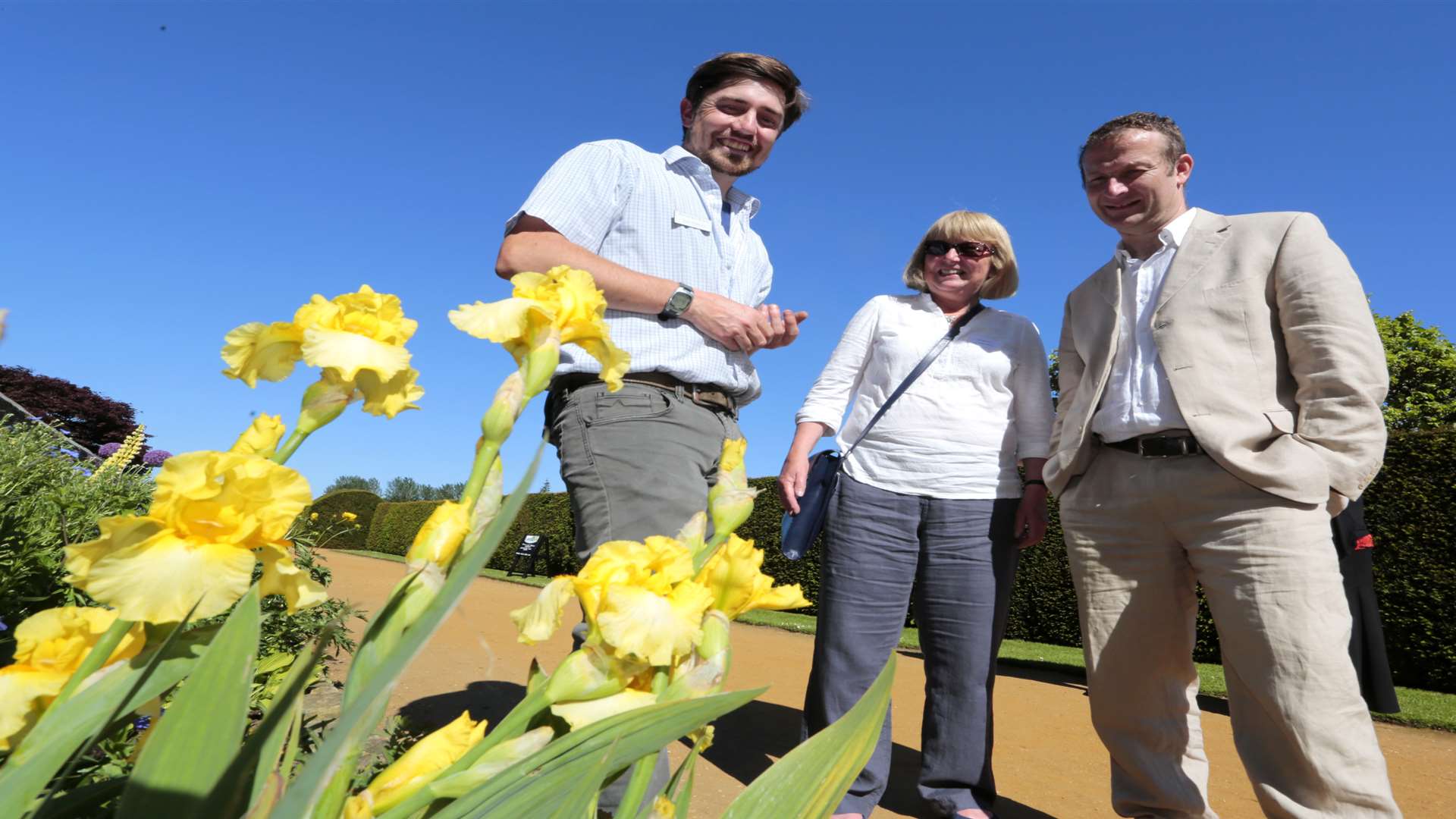 Head gardener Cory Furness, Sue Marshall, of Sissinghurst Nurseries and Andy Garland from the BBC look at the Iris Penshurst Yellow