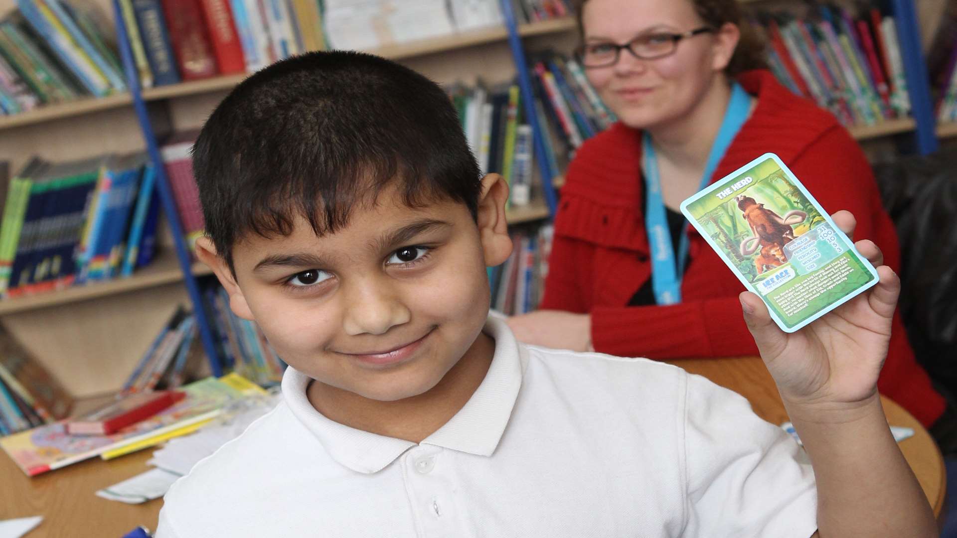 Ricardo Mosorov, seven, uses Top Trump cards with Tamara Page, a Voluntary Reading Helper