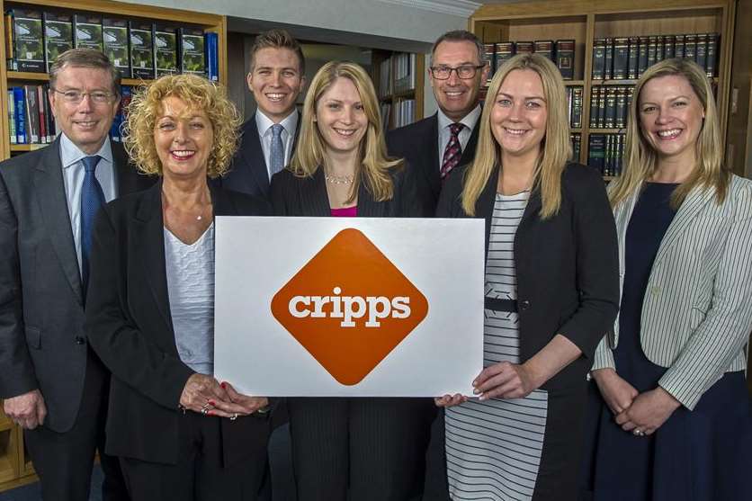 From left, senior partner Michael Stevens, receptionist Lesley Summerfield, trainee solicitor Will Bishop, deputy head of IT Jo Owen, managing partner Gavin Tyler and his PA Abby Welch and marketing assistant Steph Elliston with the new logo of Tunbridge Wells-based law firm Cripps