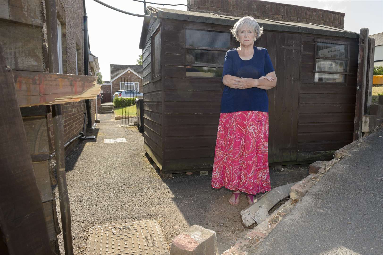 Carol Buffini, of Wyvern Close, Snodland, stands at the gap in her fence and wall where a motorist lost control of their car and crashed through into her garden. Picture: Andy Payton
