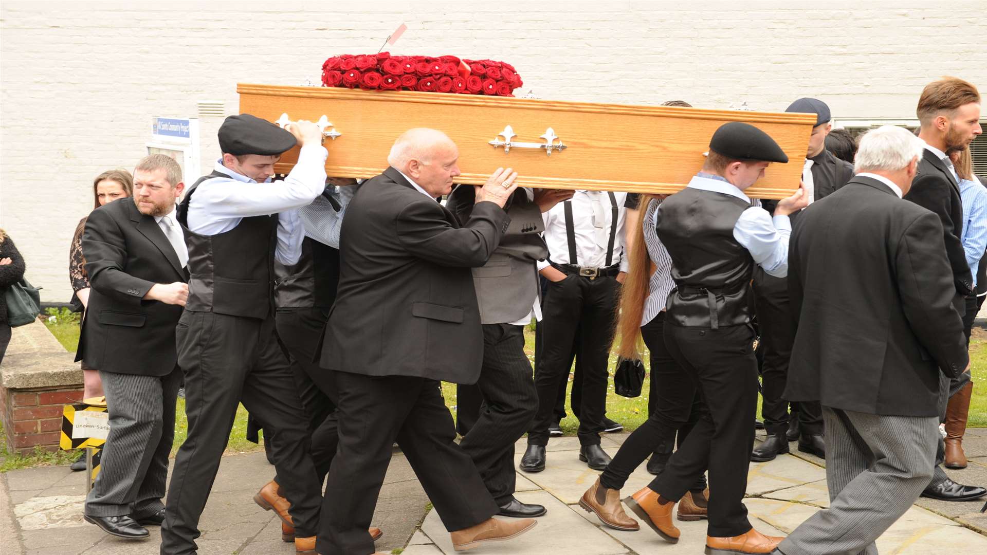 Pallbearers carry Arnie's coffin into the church
