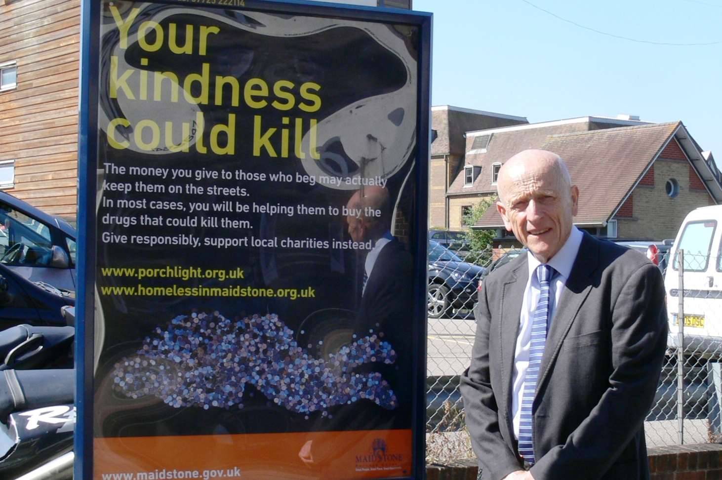 Cllr John A. Wilson with a poster promoting Maidstone Borough Council's Your Kindness Could Kill campaign
