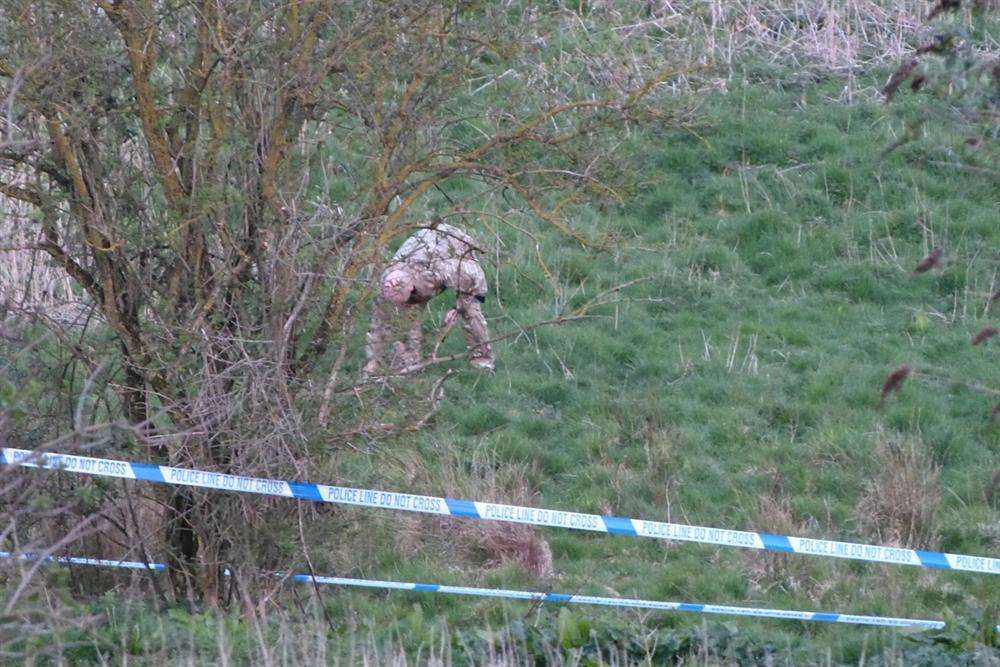 A soldier, barely visible in camouflage clothing, hunts for the grenade in Hythe. Picture: @Kent_999s