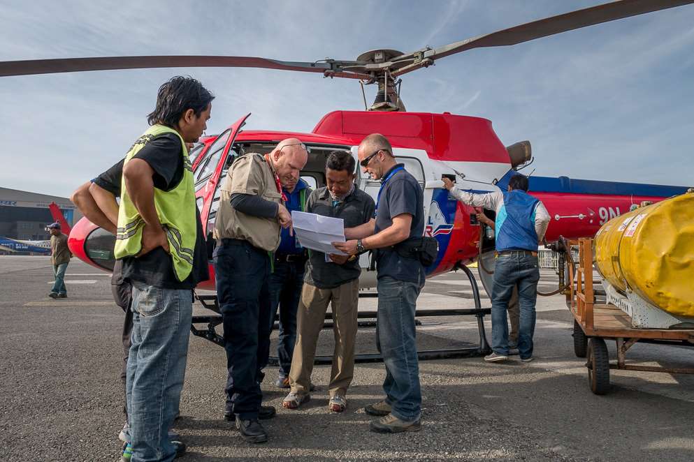 MAF Pilot Daniel Juzi coordinates helicopter flight logistics with Nepali relief workers. Picture: Dave Forney MAF