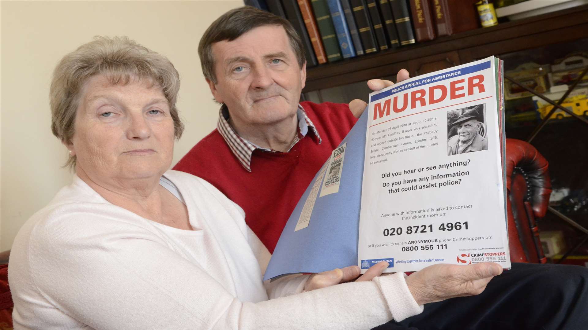 Jean and Philip Bacon with their cuttings book about Philip's dad Geoffrey who was killed in a robbery in London