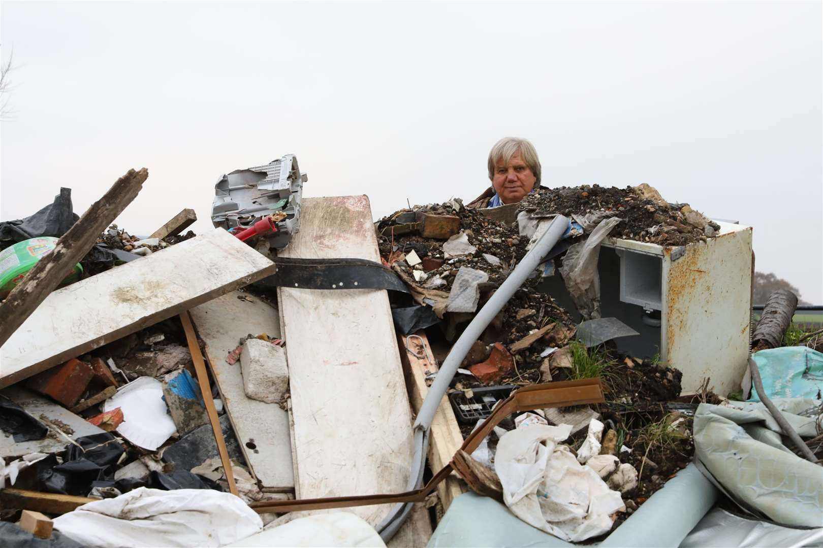 Lester Gosbee behind the pile of fly-tipped builder's rubble