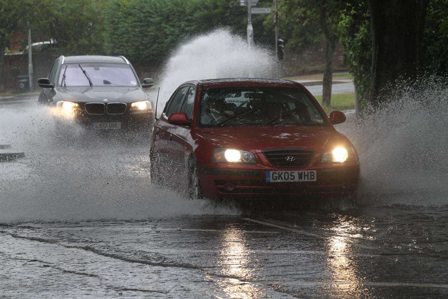 Cars travel through a flooded area on Bell Road, Sittingbourne