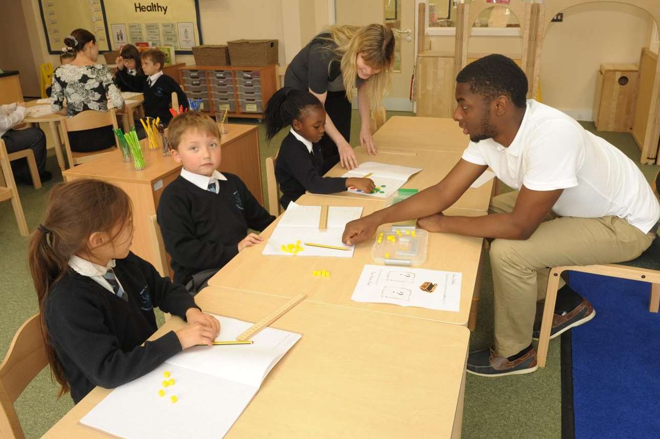 Teaching Assistant Marlon Somers helps Year Two pupils with their work. Picture: Steve Crispe.