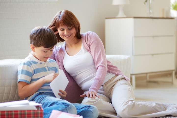 Mother and son opening their National offer day letter. iStock.com