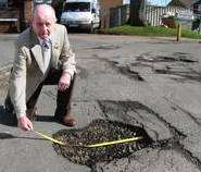 Street inspector Fred Whale measures a pothole in St Mildred's Place, Wincheap