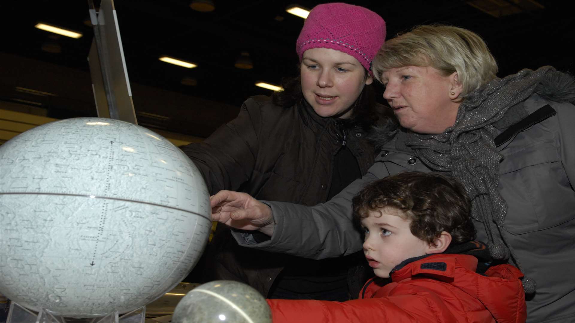 Louise Ford, Linda Burrows and Seth Ford look at a star globe.
