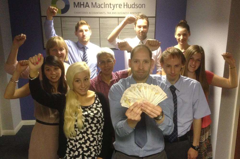 Ron Hazelwood and the team from MHA MacInTyre Hudson in Maidstone are holding the £250 cash prize that could be won at the Maidstone KM Big Charity Quiz