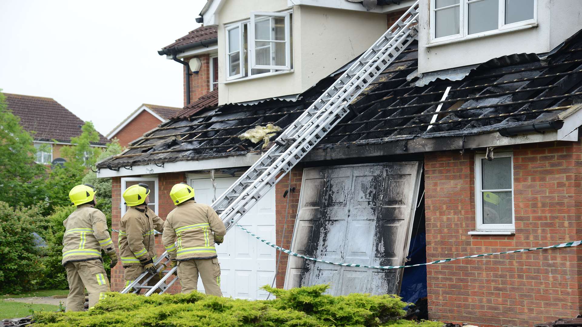 Firefighters at the scene following a house fire Wood Lane