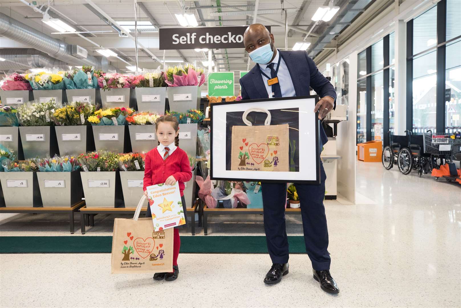 Eden Beevor receives a frame copy of her bag design from store manager Kwadwo Osei