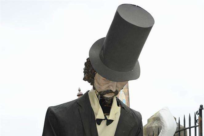 A giant model of the great author makes its way along the High Street