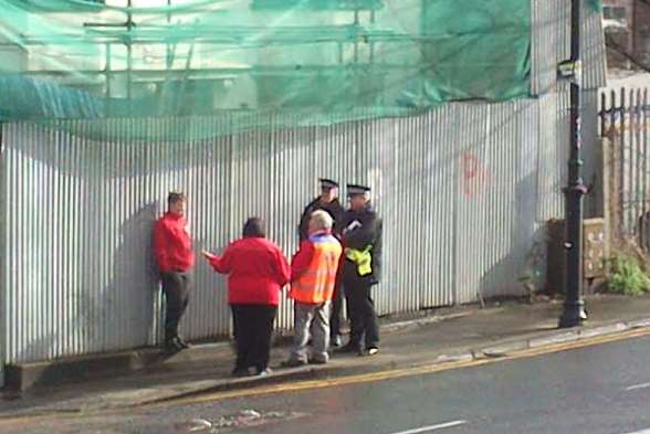 Police talk to Royal Mail workers near the sorting depot