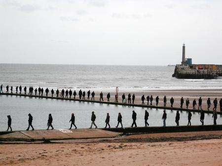 A hardy group of walkers complete seven circuits of the bathing pool on Margate Main Sands for an installation at the Turner Contemporary by the Kent artist Hamish Fulton