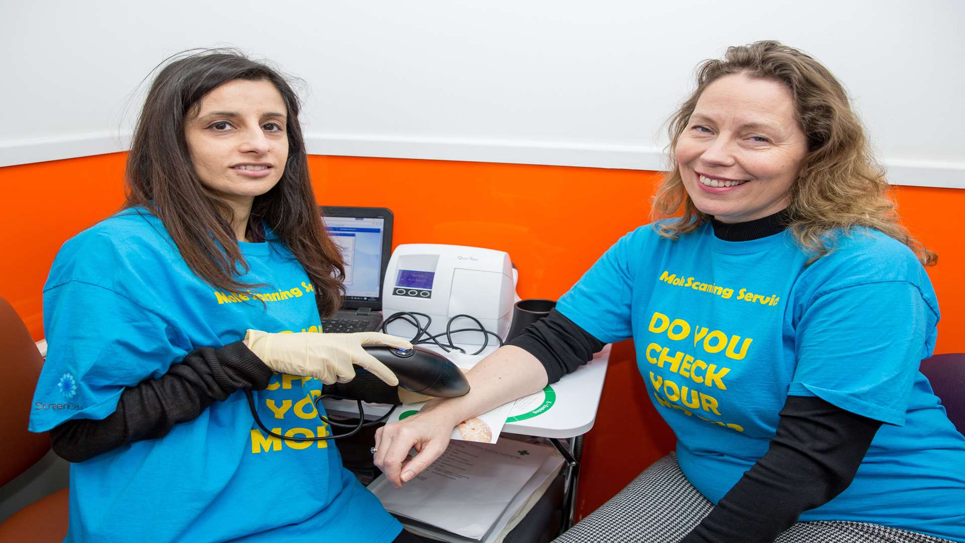 Raj Sandhu, health care assistant, demonstrates the equipment on Tina Soskind from ScreenCancer UK. Picture: Matthew Walker