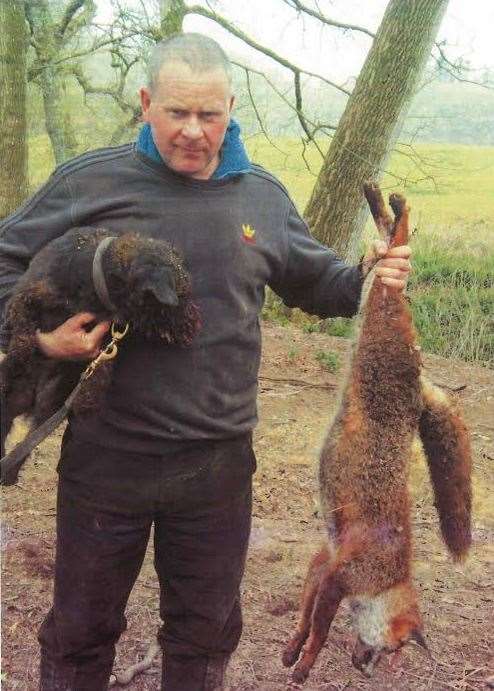 Cruel Steven Alston poses with his injured dog and a dead fox