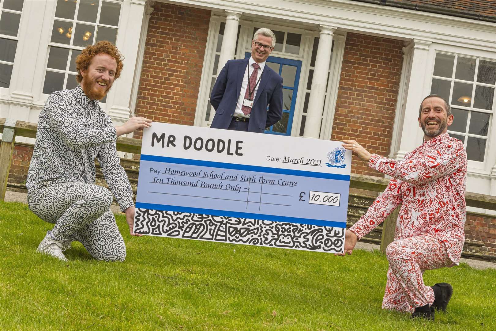 Sam Cox - also known as Mr Doodle - presents the cheque to Homewood head Jeremy Single (centre) and teacher Morgan Davies. Picture: Steve Town