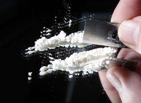 Stock image of cocaine being cut