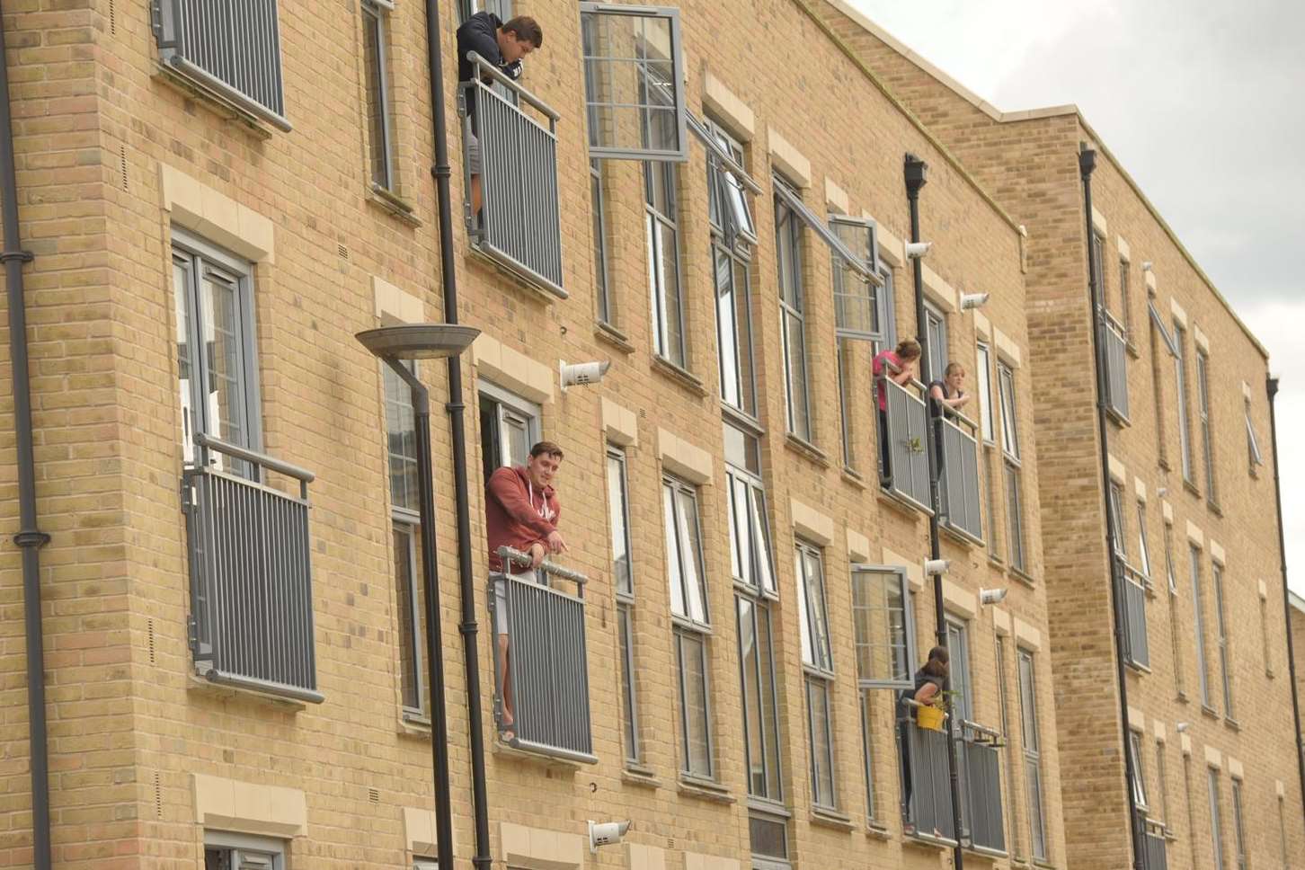 Neighbours look out of flats at the police operation. Picture: Steve Crispe