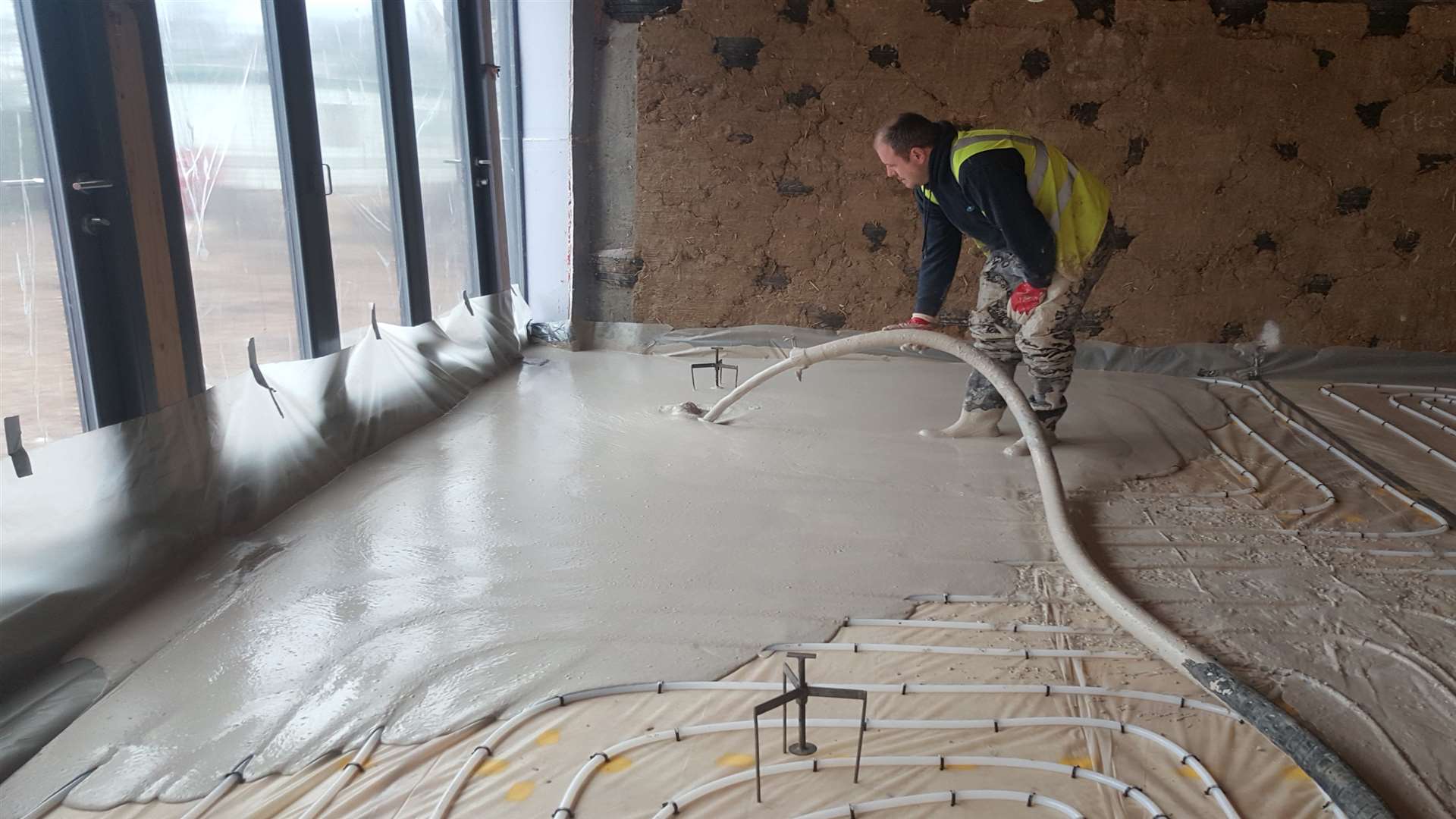 The underfloor heating pipes are covered by 98% recycled marine-dredged screed is poured and levelled using 'spiders'on the floor