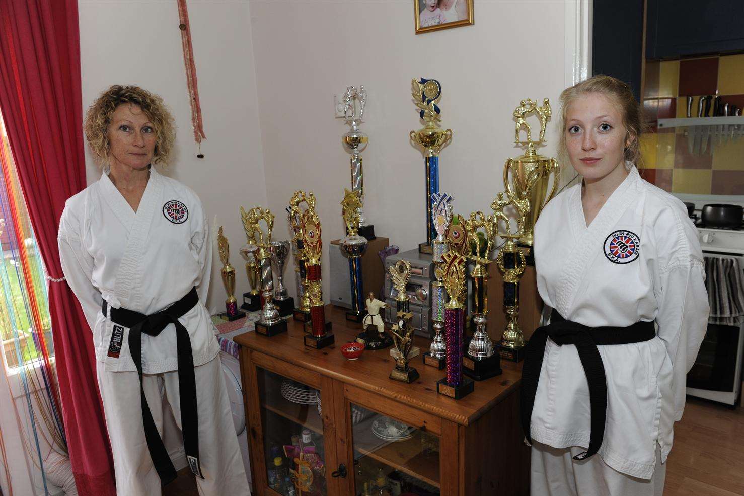 Kara and Megan proudly display their trophies and black belts