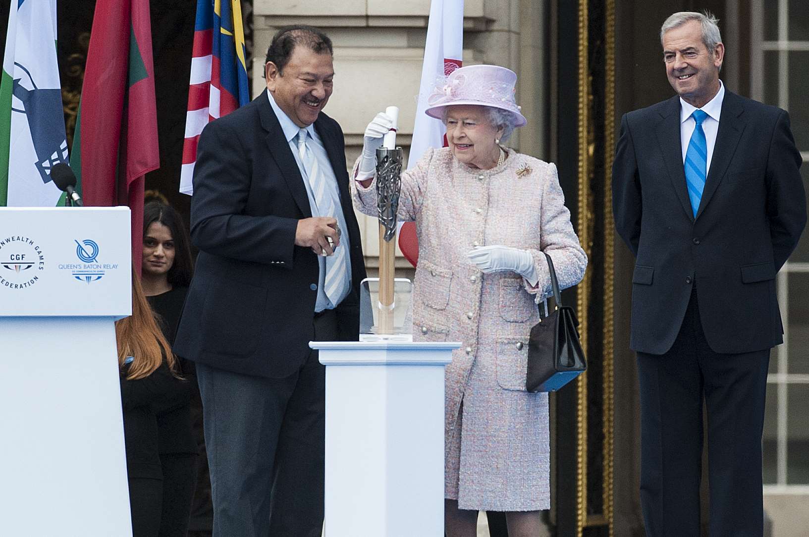 The Queen lights the baton at the start of its journey