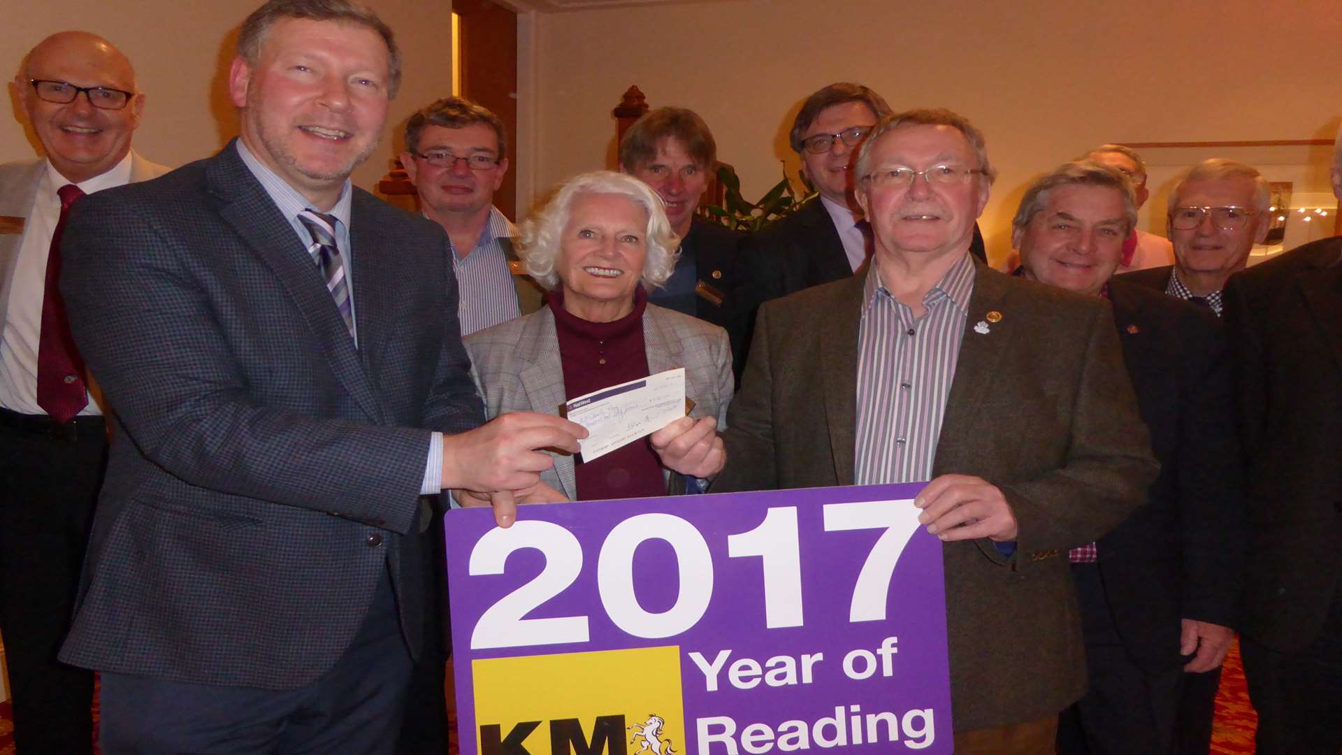 Maidstone Riverside Rotary members watch Carolyn Bassett and President Steve Elms present Simon Dolby with a donation of £250 to fund Barming school's involvment in Buster's Book Club.