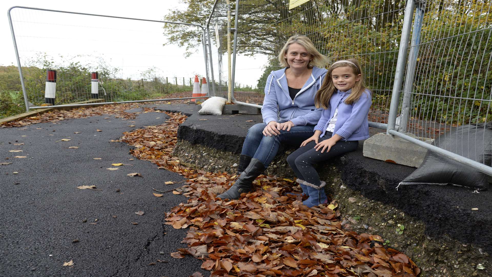 Jenny Wallis and daughter Eve with the large pothole in Dawes Road, Hernhill which is going to be repaired