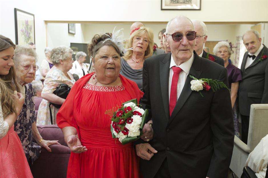Newly-weds Ted Newins and Gloria Blandford walk along the aisle greeting friends