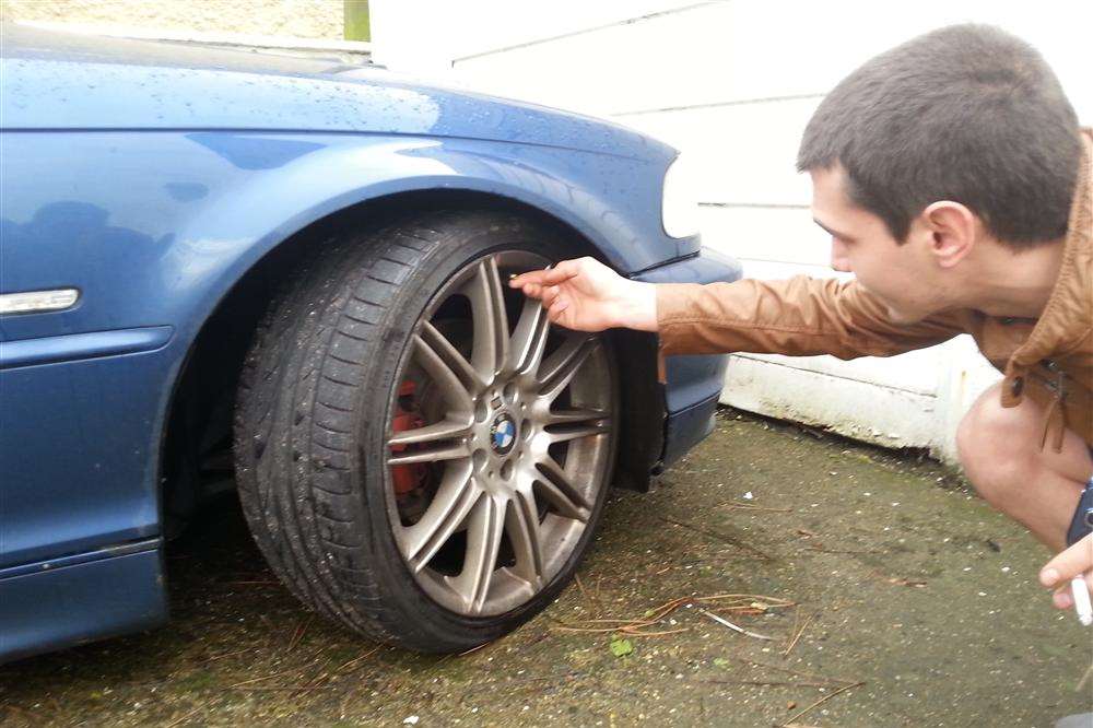 Mr Ivanov inspects damage to his car tyres which he believes have been targeted because of his nationality.