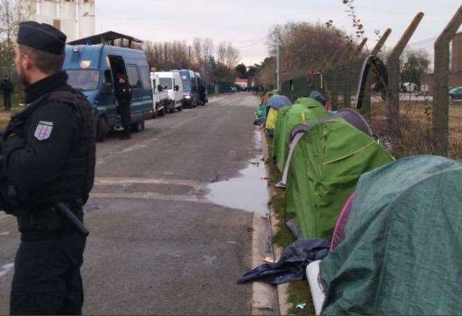 French police next to tents lining the road in Calais Picture: Poppy Cleary