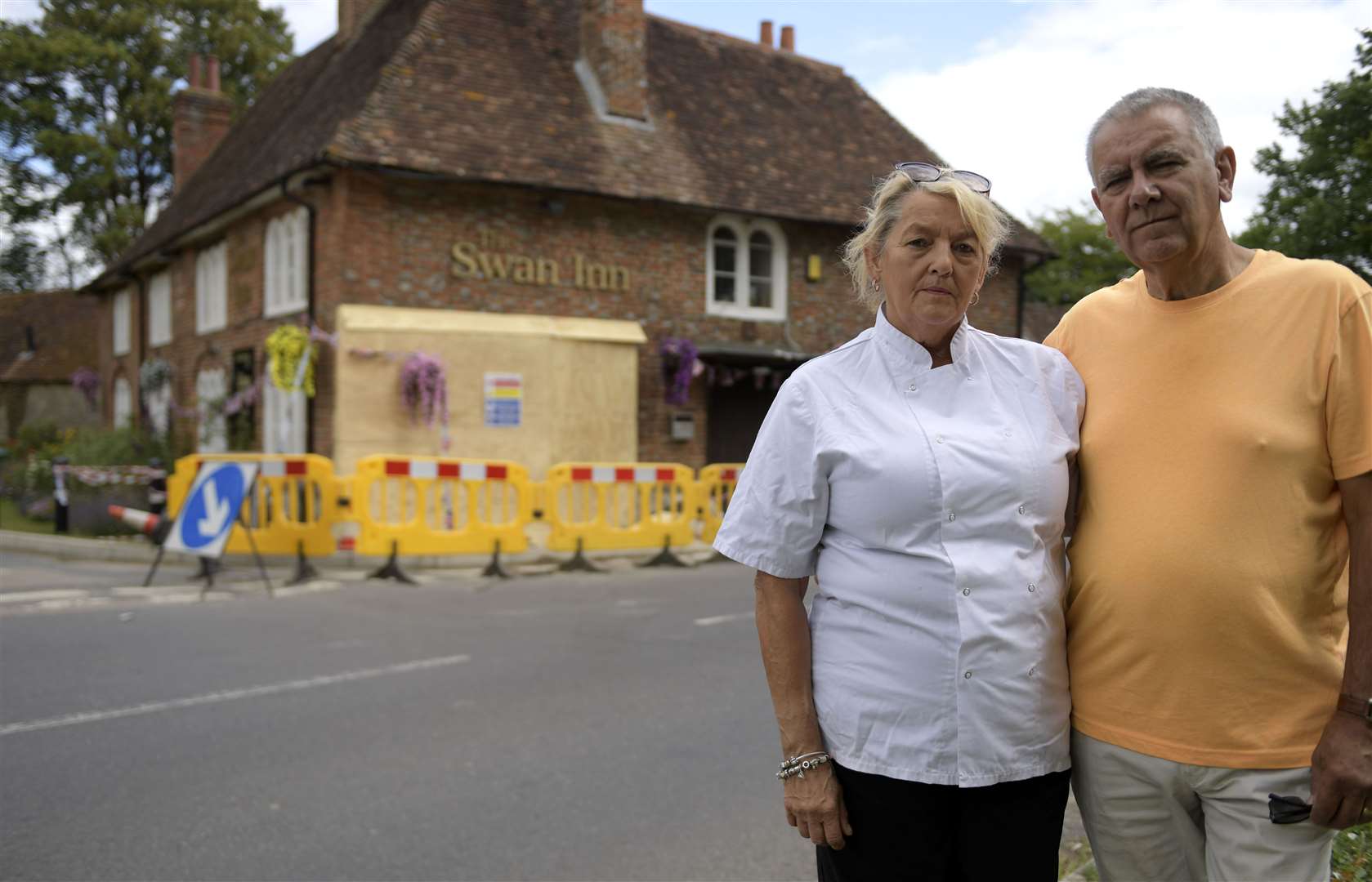 Ann and Ray Perkins in front of the Swan Inn's damaged wall in July. Picture: Barry Goodwin