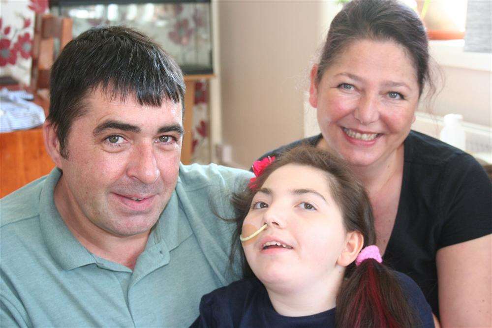 Isidora Dyer, 14, who is fighting severely debilitating Rett syndrome, with her parents.