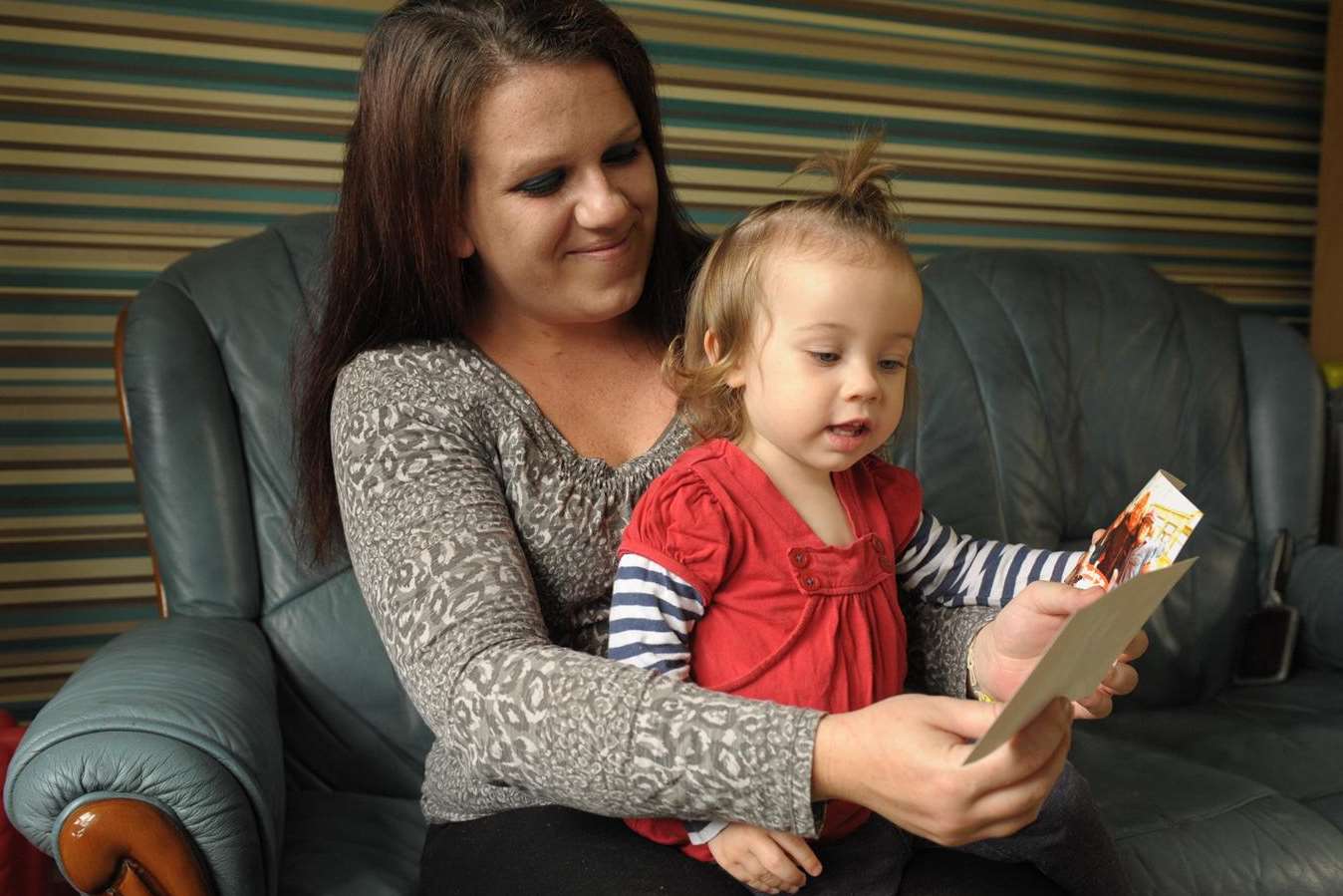 Kate Jarrett and daughter Sophie, one, looking at photos of Kate’s mum and sister